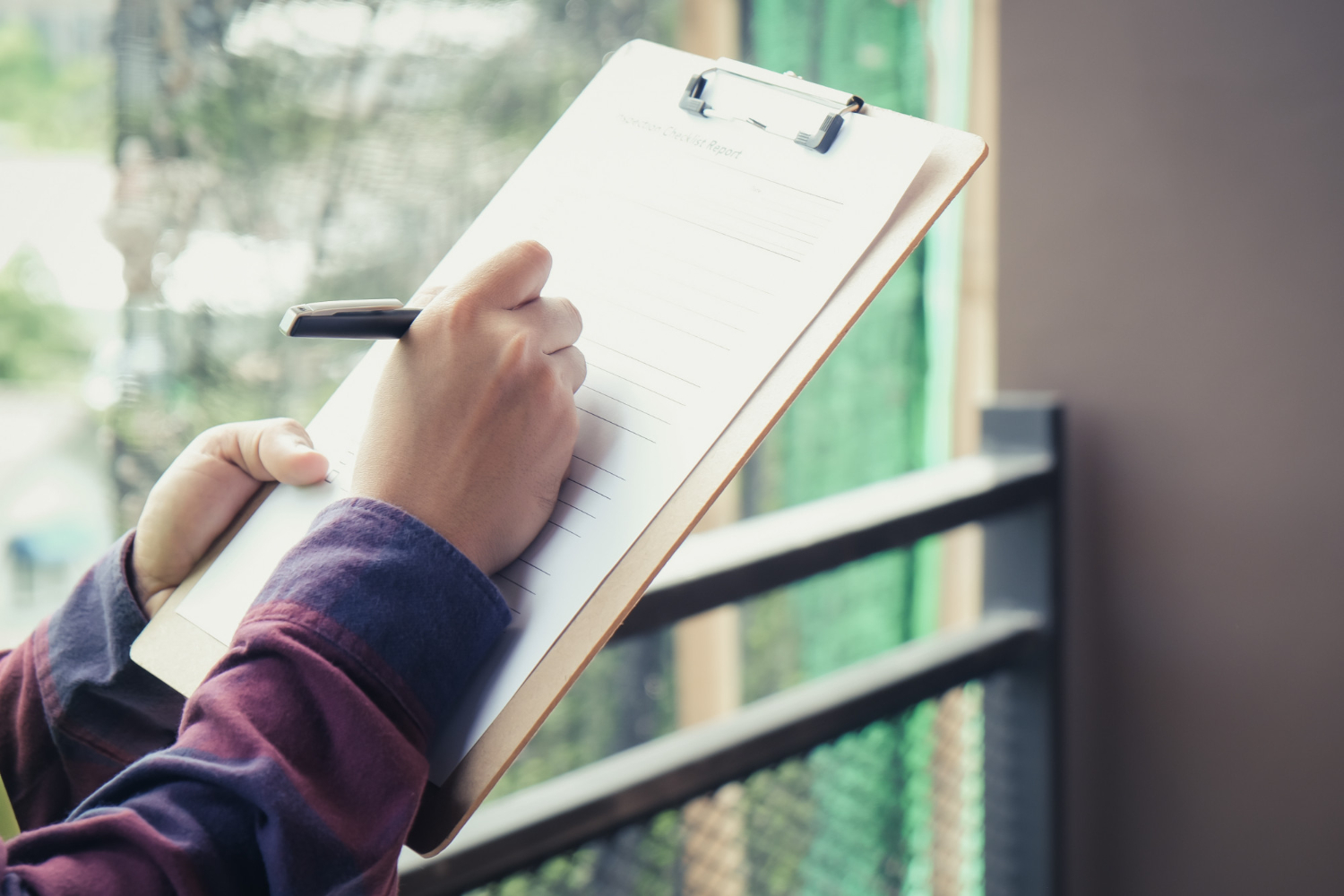 Contractor on clipboard writing notes